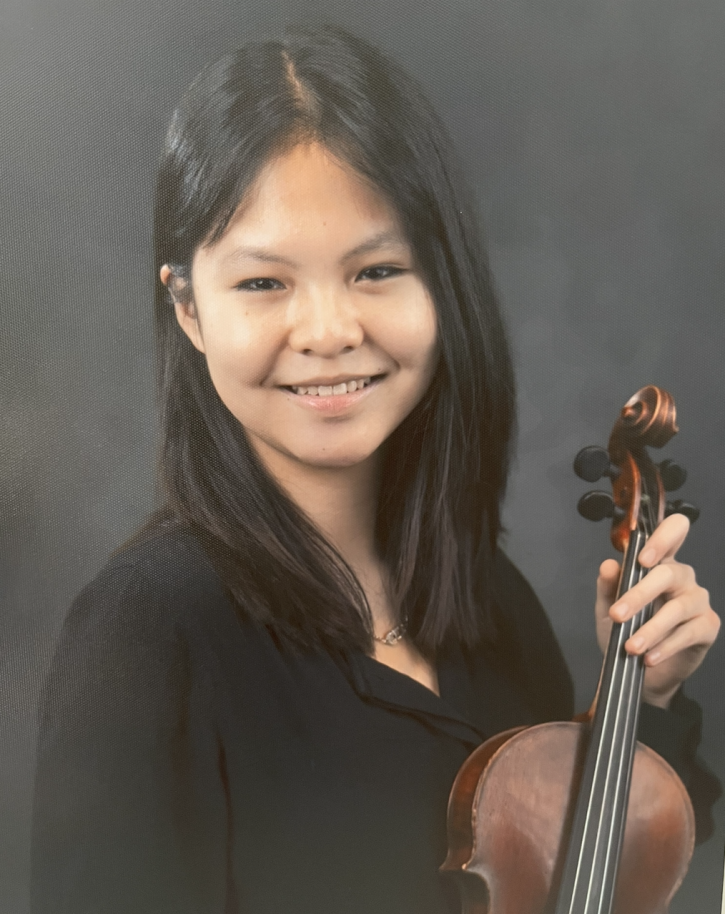 Alexia Fang holding a violin, smiling and dressed in concert black