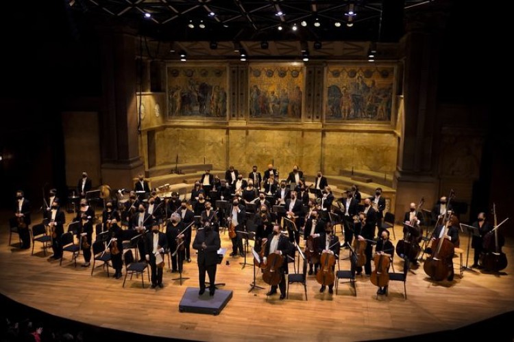 A wide shot of the stage at Richardson Auditorium, showing the musicians of the PSO and conductor Kenny Bean standing for audience applause