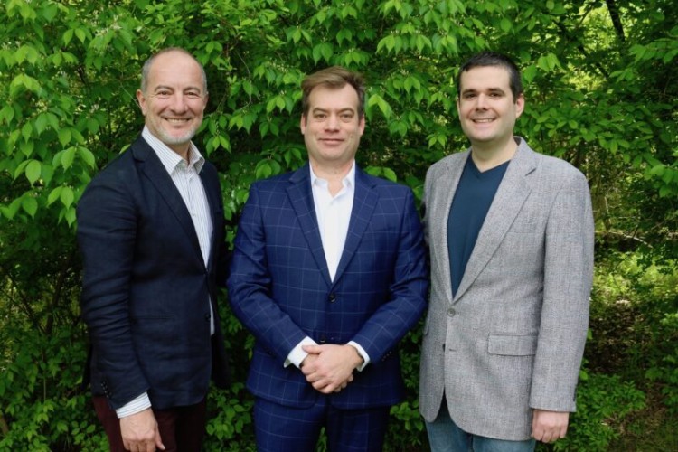 PSO Music Director Rossen Milanov, Executive Director Marc Uys, and Festival Director Gregory Geehern standing in front of some trees, smiling at the camera