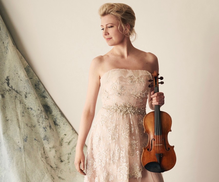 Elina Vähälä in concert dress holds her violin.