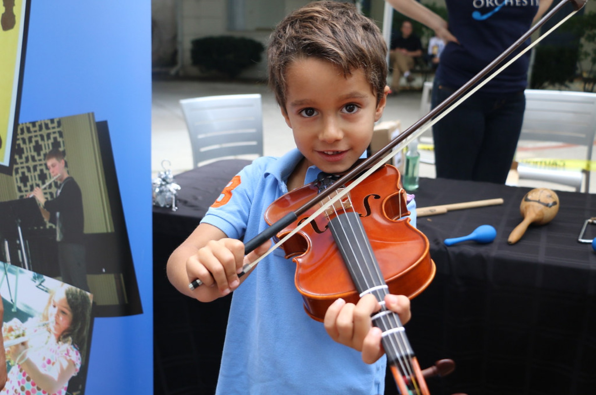 A young boy holding a violin and bow
